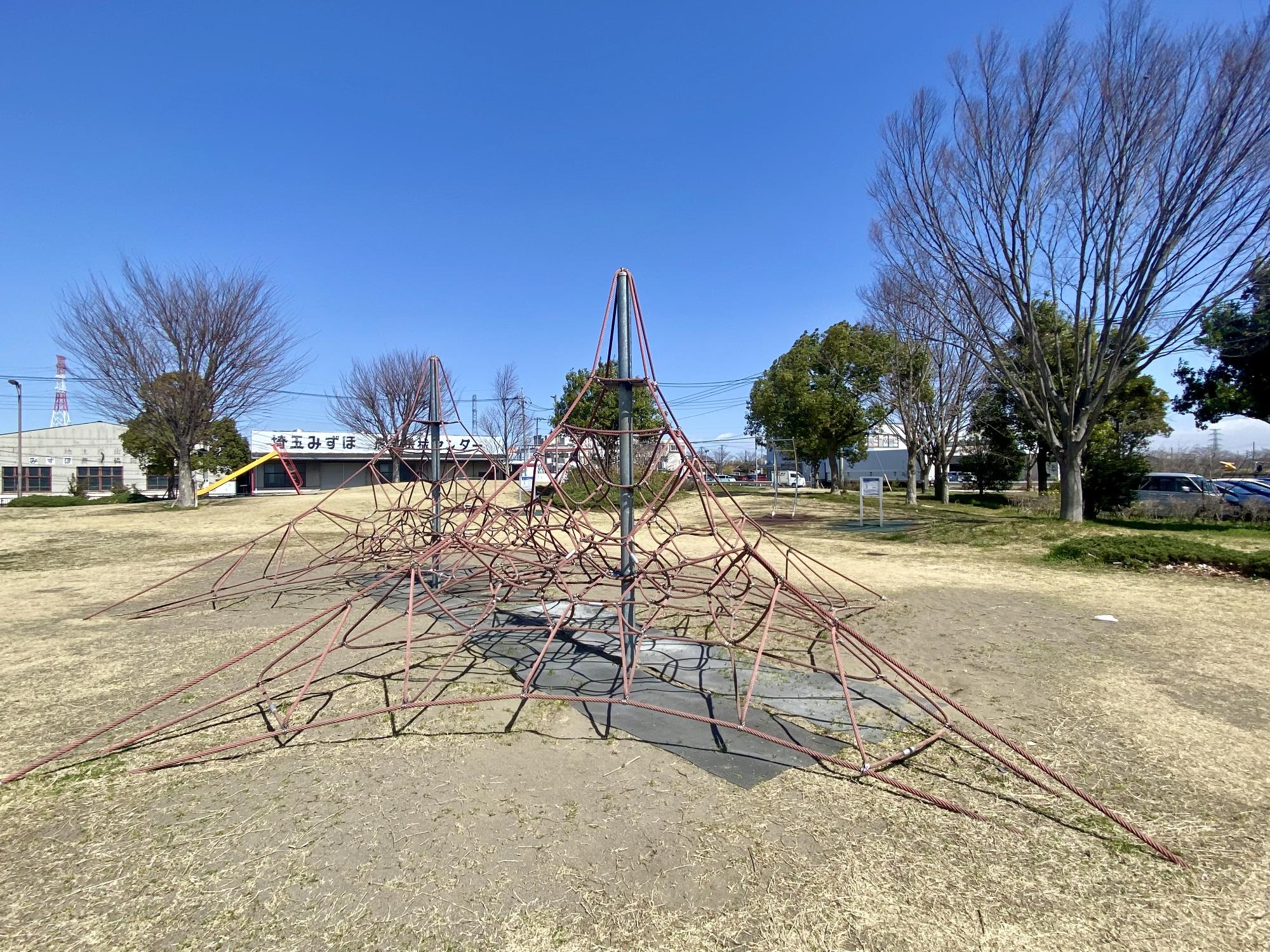 園地にある赤色のあみの遊具の写真