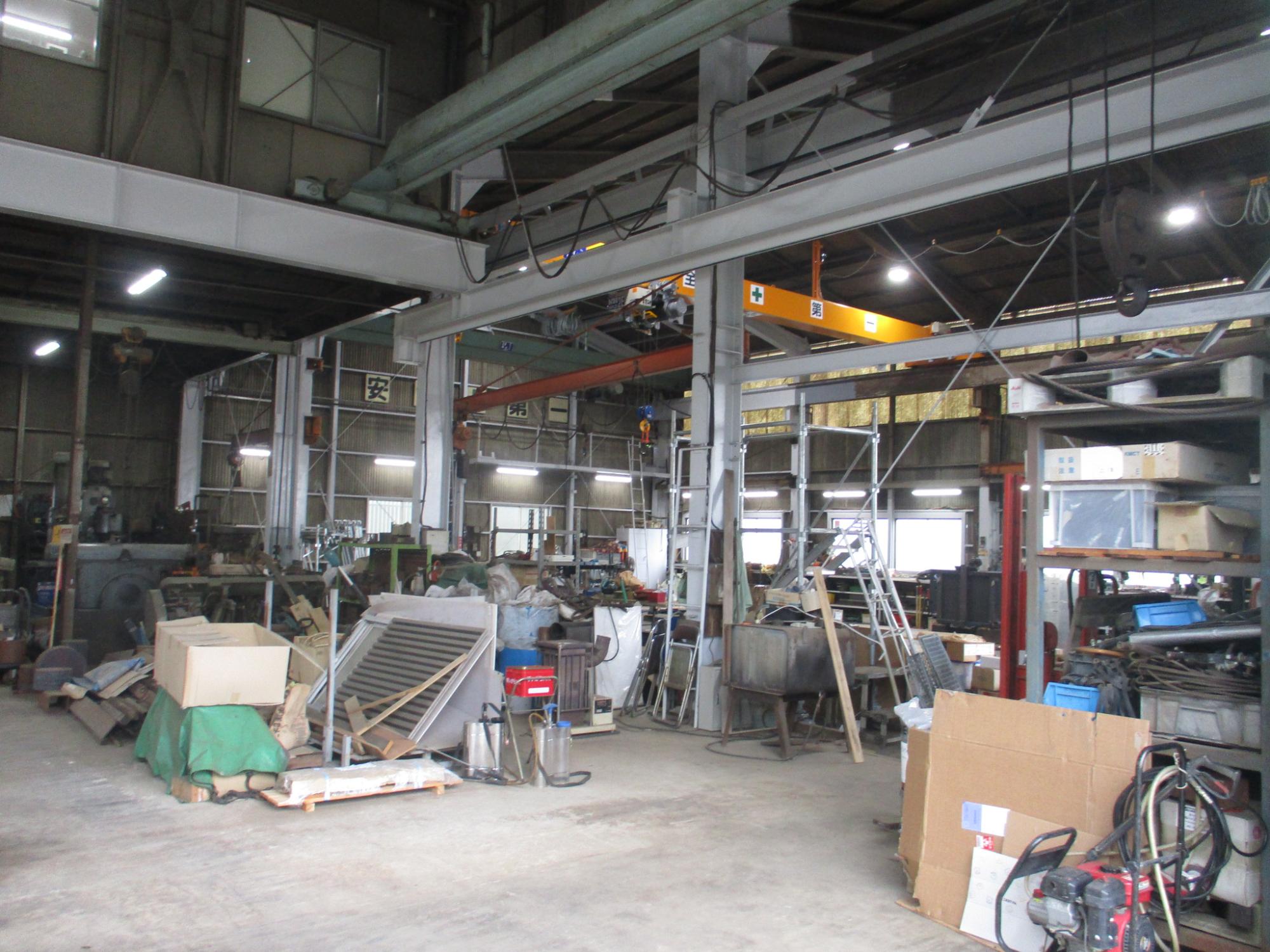資材がたくさん積まれている作業工場の写真
