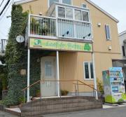 卵色の温かみとアイビーや看板文字の緑のコントラストが特徴的な建物の写真