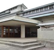 白いコンクリート地の壁に黒い瓦を使い武家造風にした建物の写真