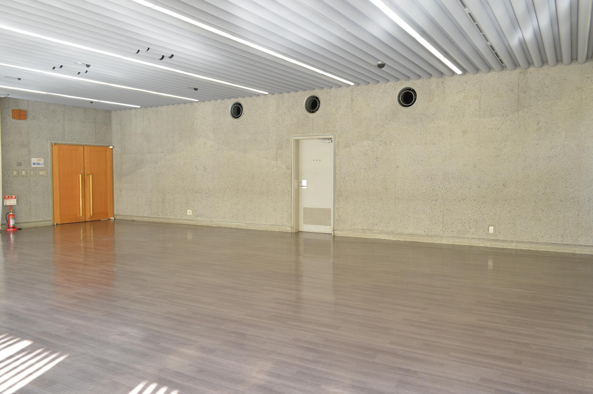 オレンジ色のドアが特徴的な広々とした部屋の写真