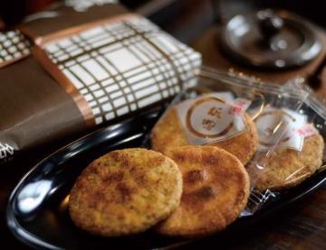 漆器の皿に載せられて提供されている栃惣せんべいの写真