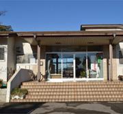 茶色いタイルで出来た階段の先にある薬師沼憩いの家入口の写真