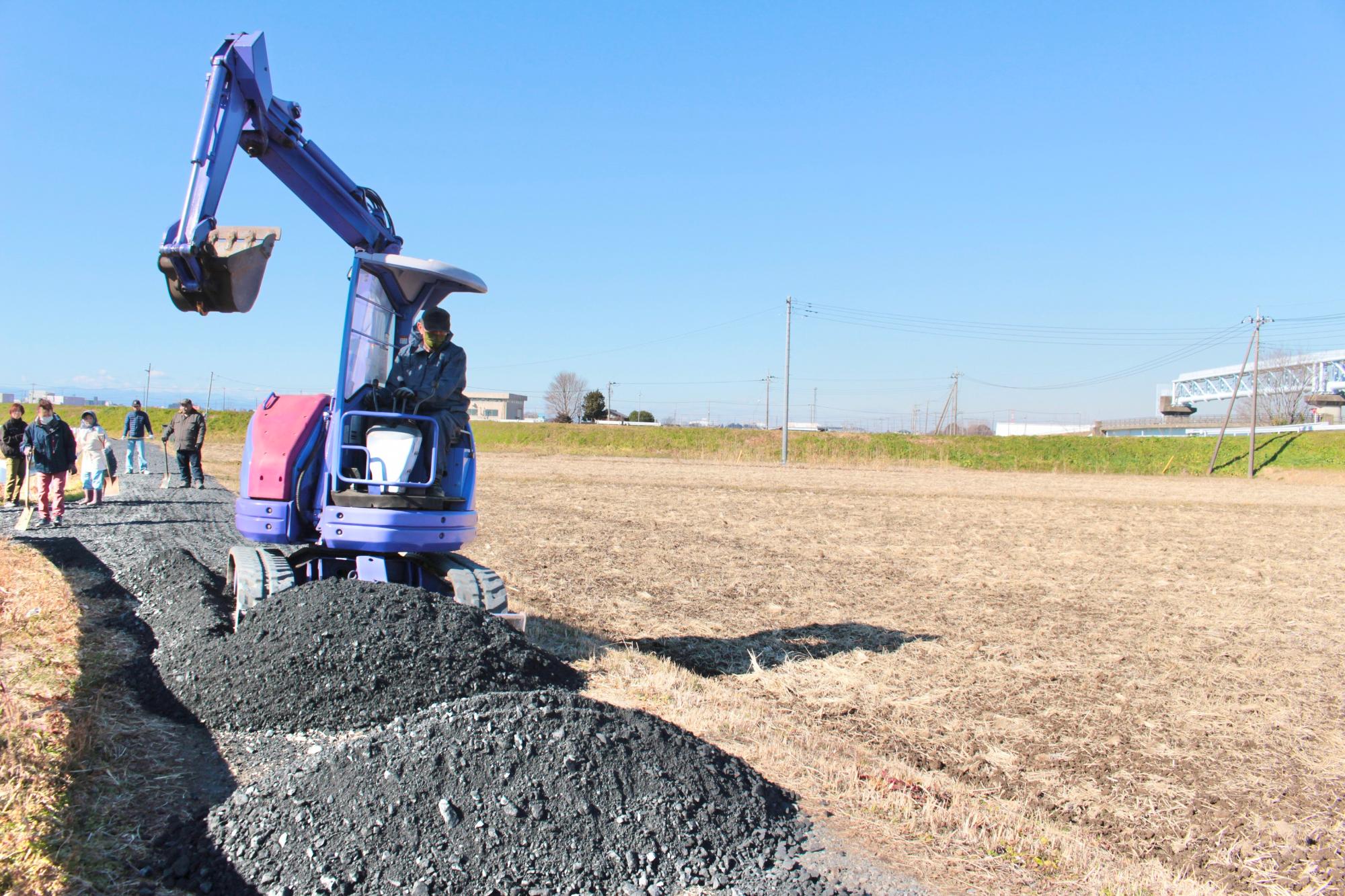 重機で砂利を敷きならす様子