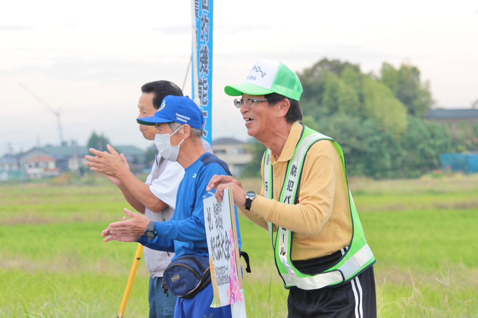 飯沼中学校美術部制作の看板を持って応援する組合員