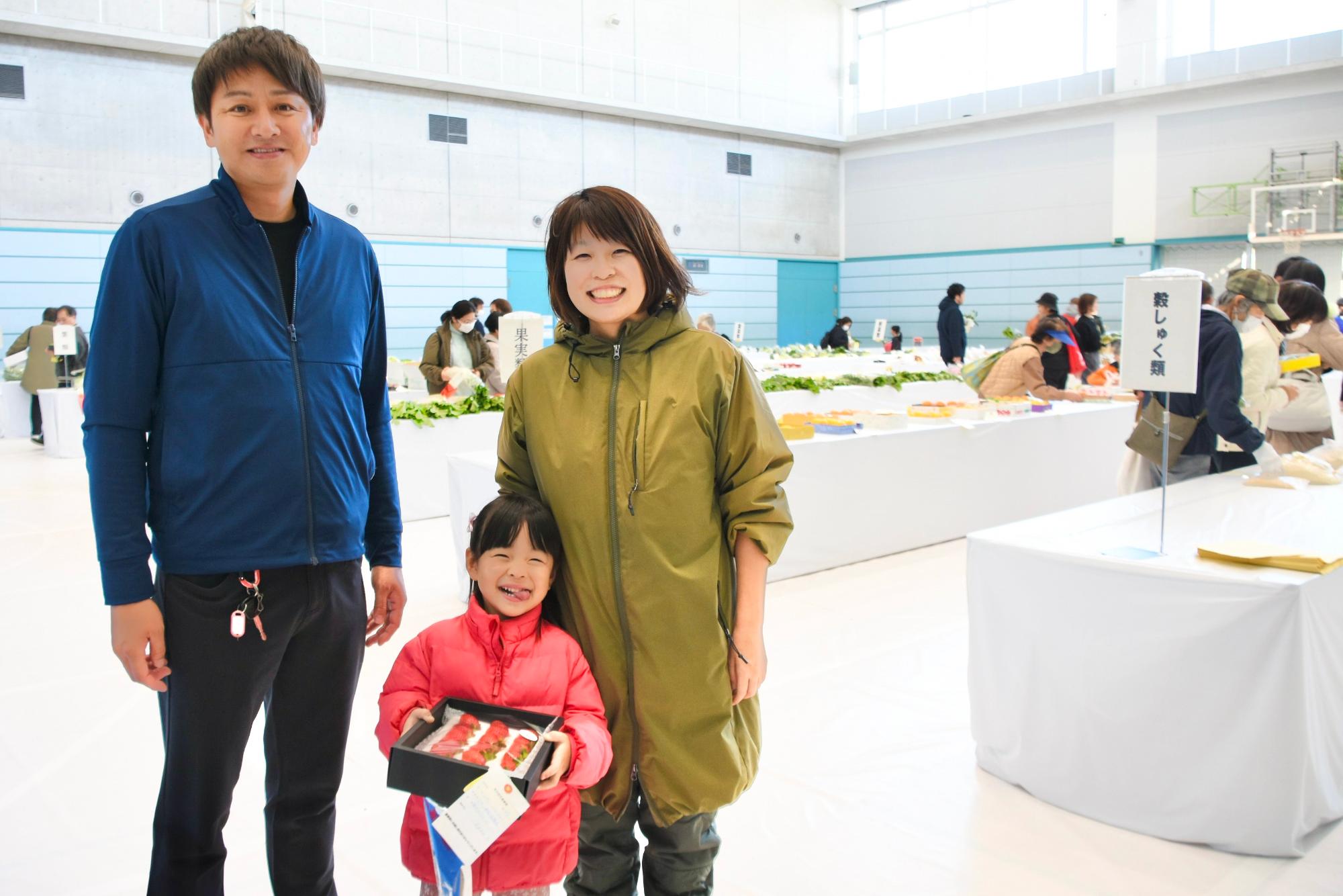 即売会でイチゴを買った親子とその生産者