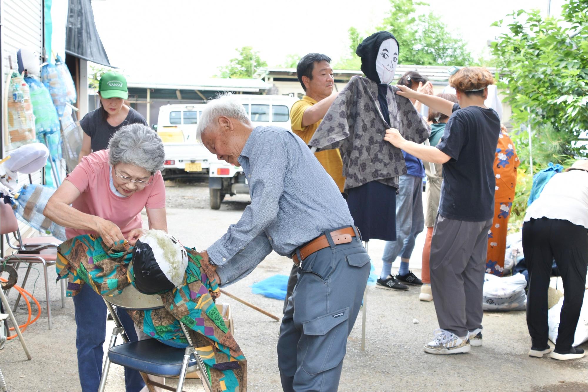 かかしに古着を着せる様子
