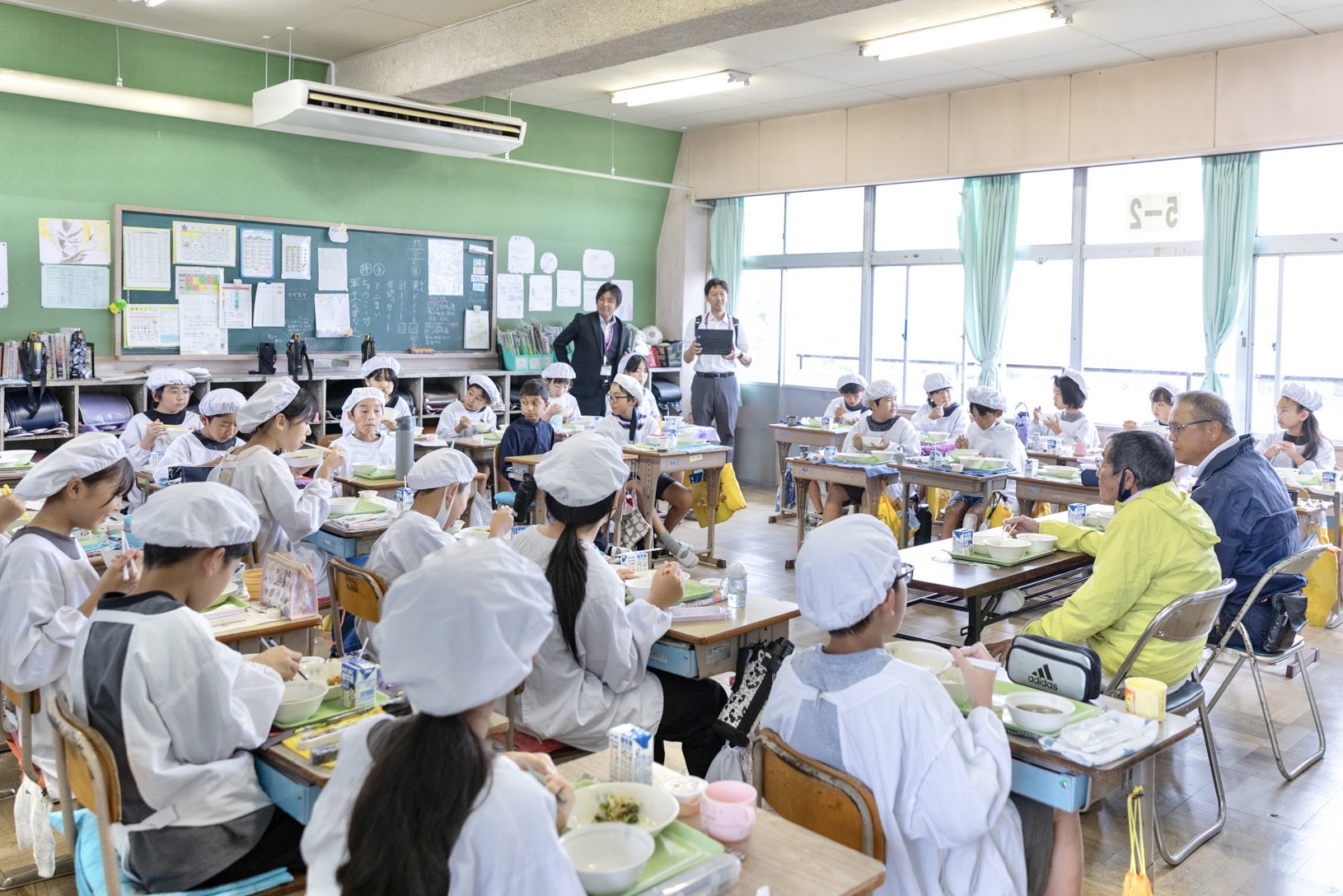 子どもたちと一緒に給食を食べる農家さん