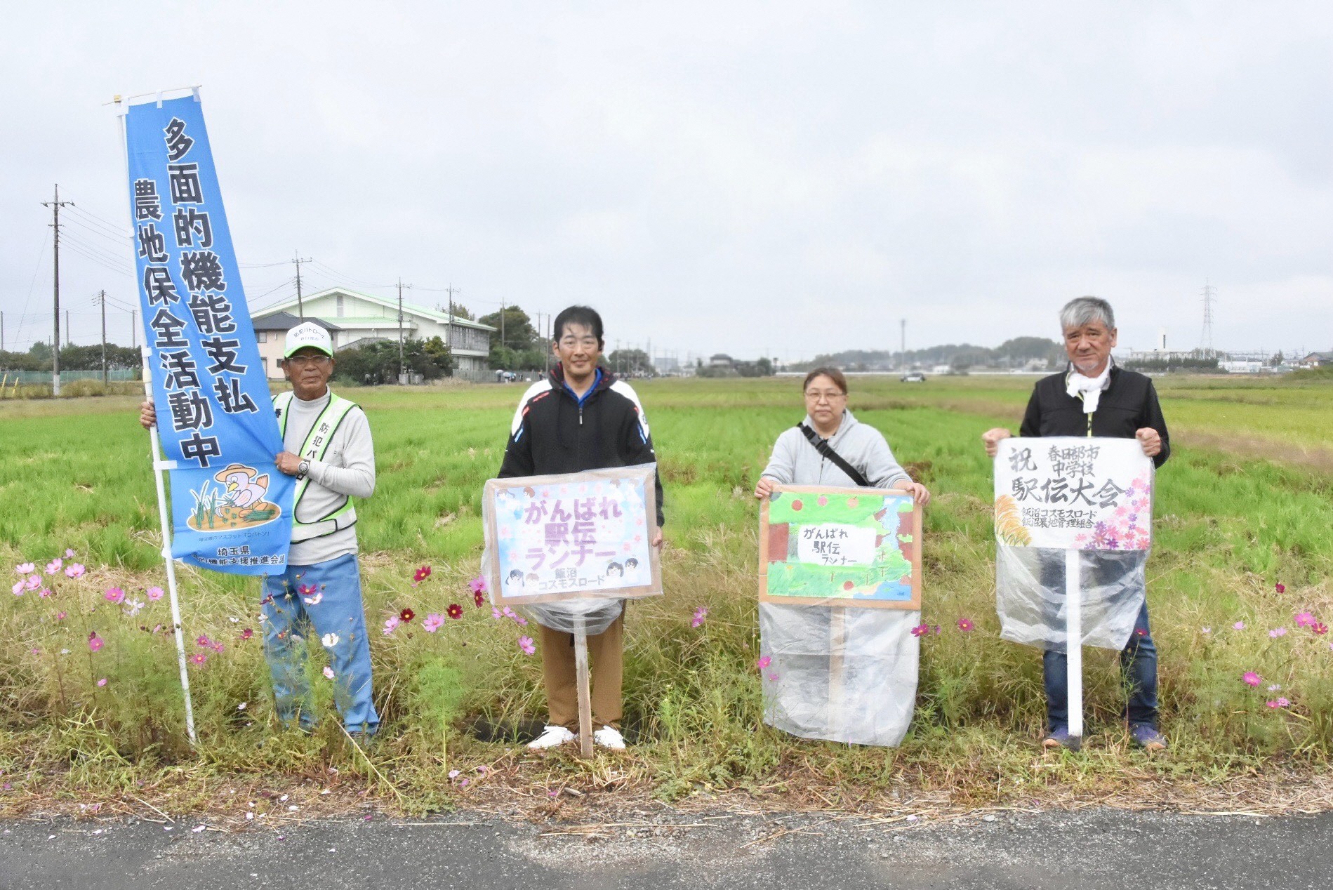 飯沼中学校美術部制作の看板を持って応援する組合員