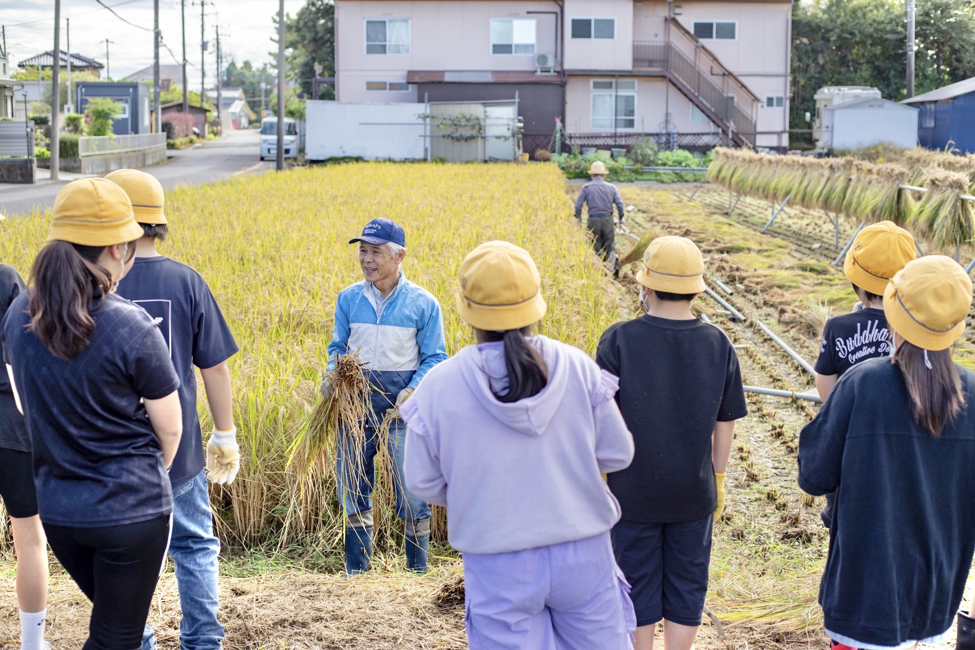 稲刈りについて説明する筒野さん