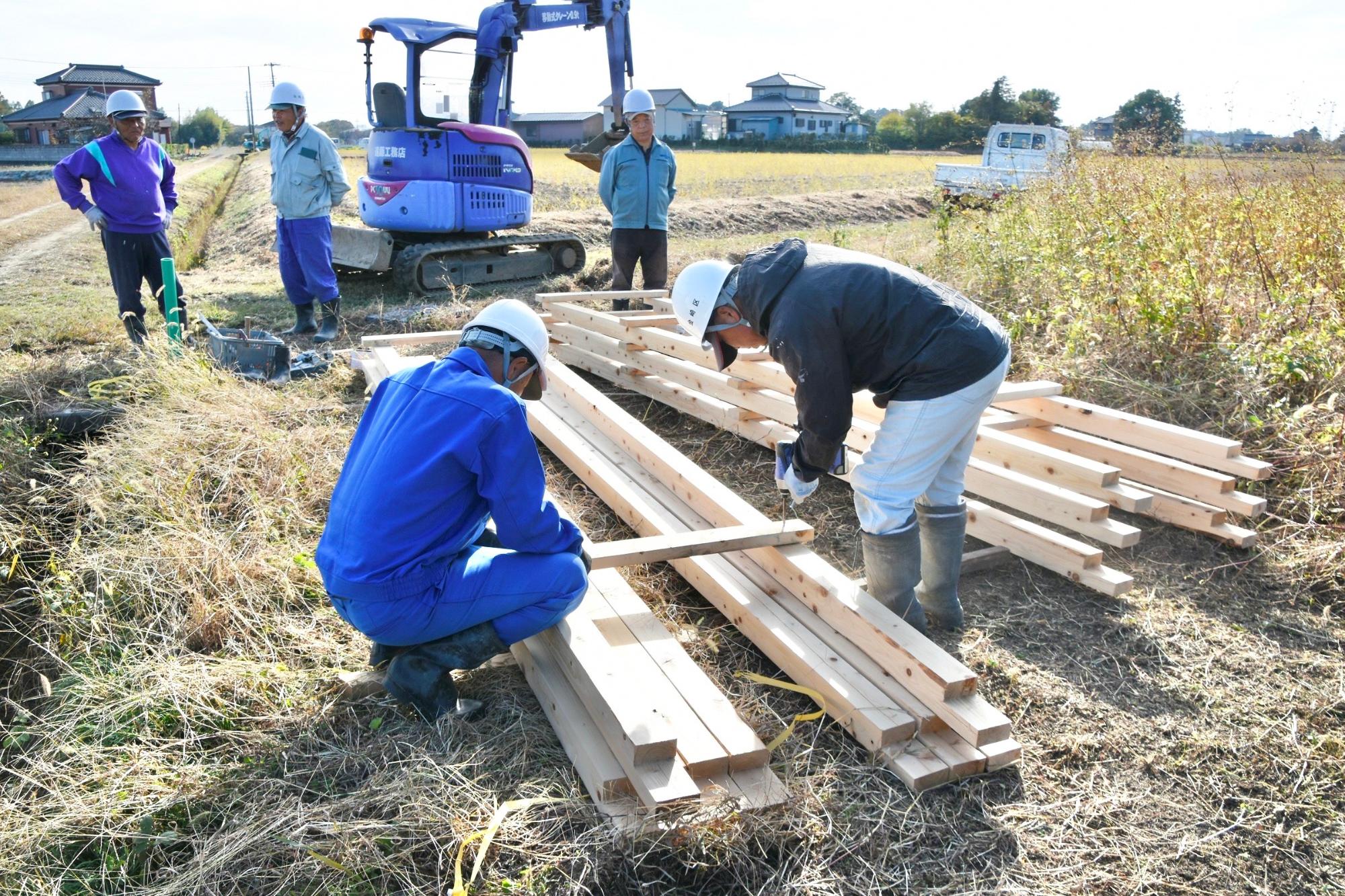 水路の下に敷く枠を組み立てる様子