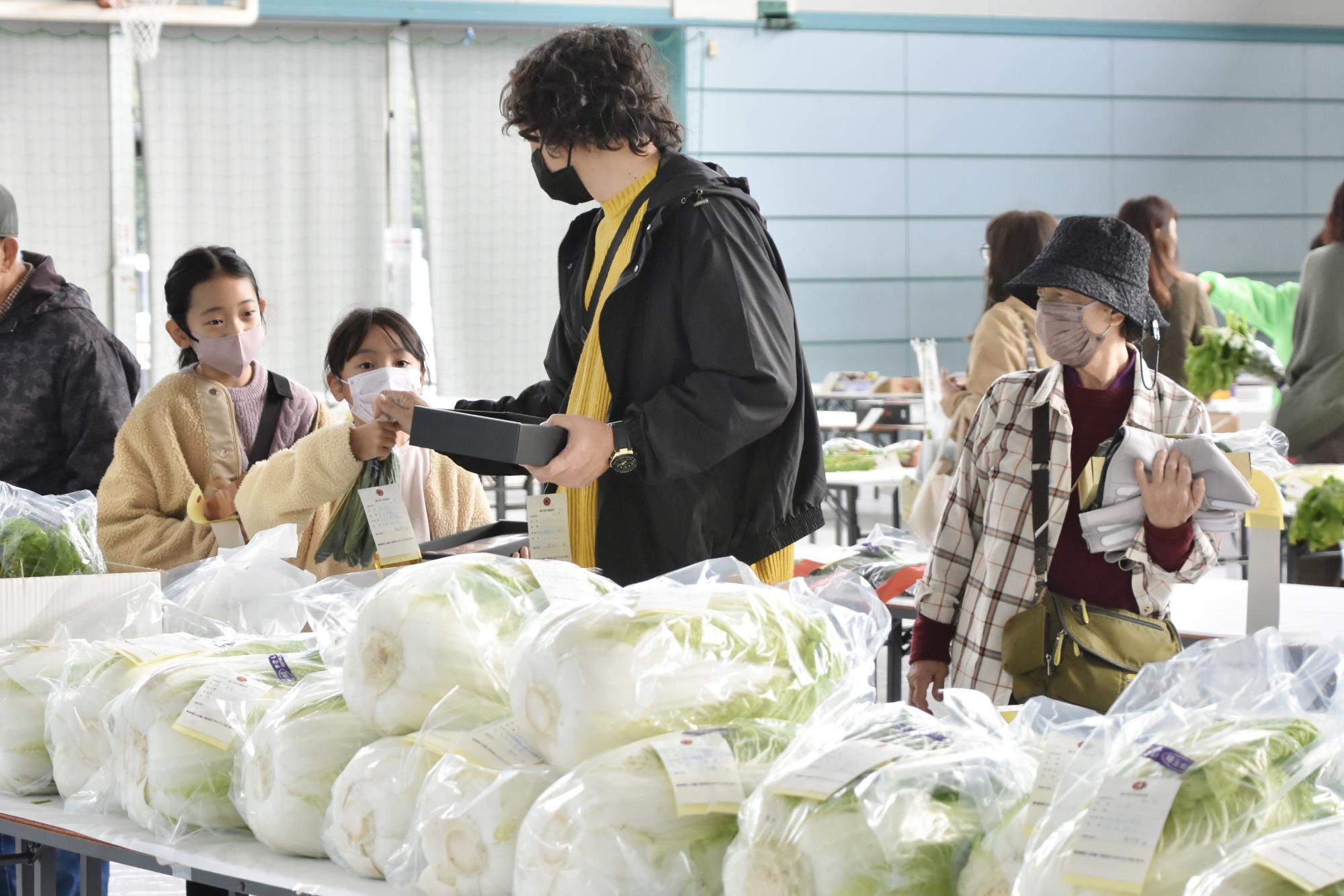 即売会で野菜を選ぶ家族