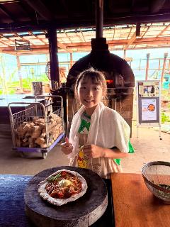 ピザ釜の前でピザと写る子