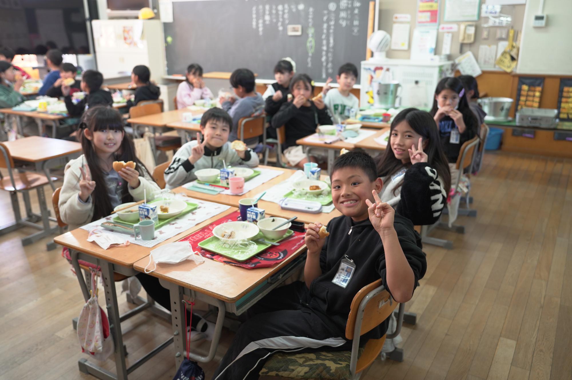 給食のライスボールを食べて笑顔の子供たち