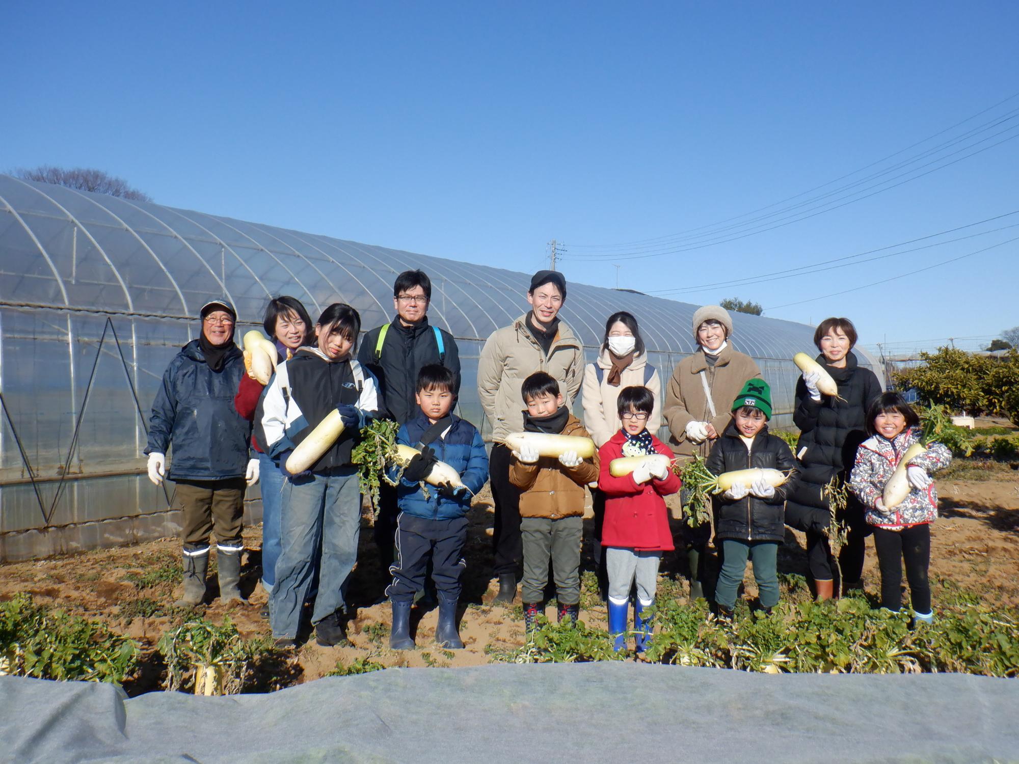 収穫した大根を手に集合写真