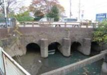 曇天の下、車が行きかうめがね橋(近代文化遺産)の写真