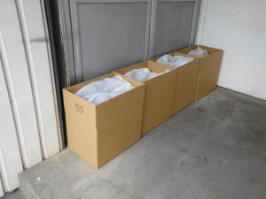 水を入れたビニール袋を段ボールに入れて、建物入り口に置く土のうの代わりにしている写真