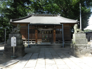 生い茂った木々をバックに東八幡神社の本殿とその左右前方に対面で建つ狛犬像の写真