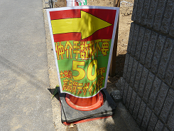 カラーコーンに貼られた条例違反の張り紙の写真