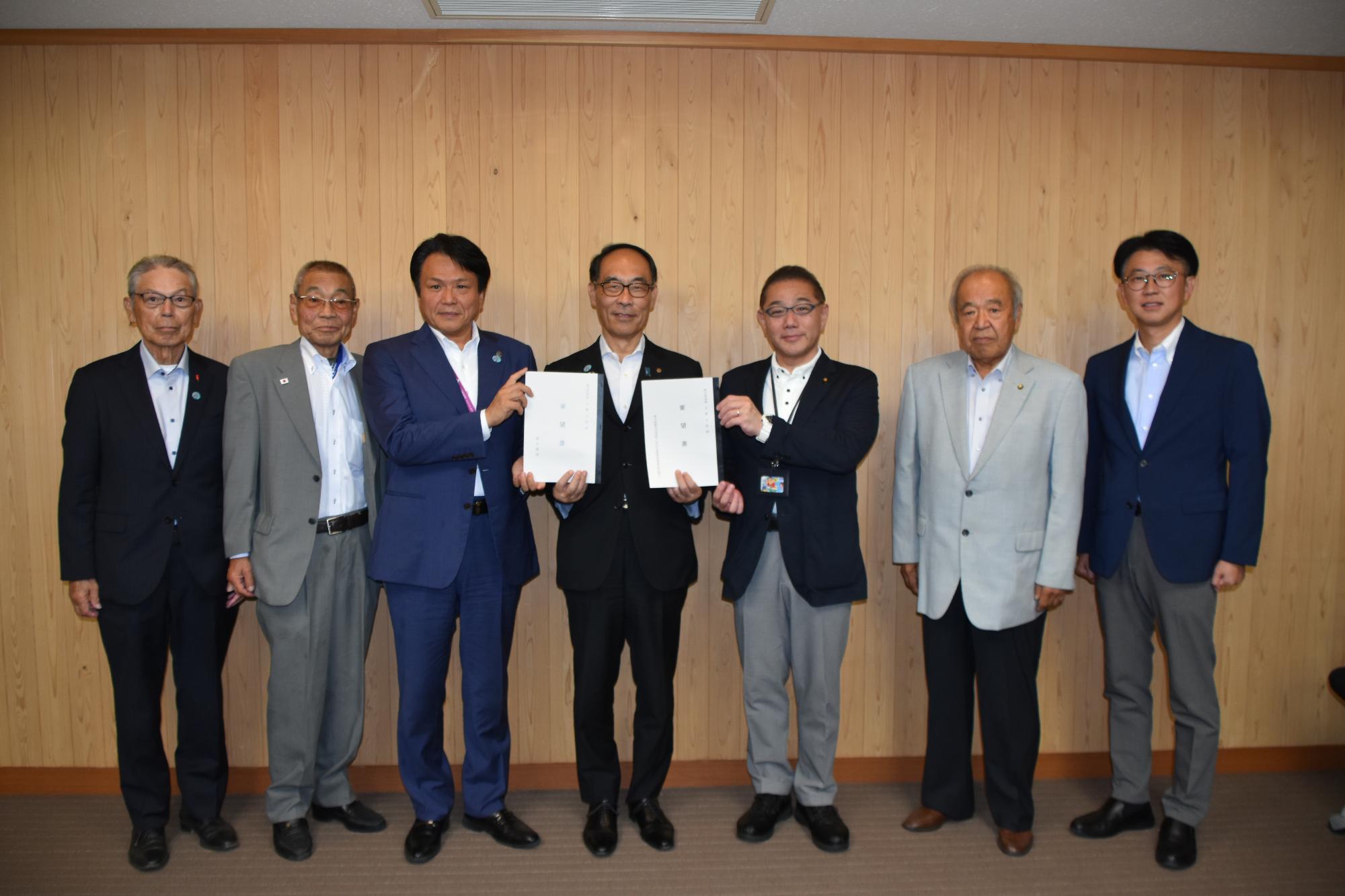 要望書を持つ岩谷会長と大野知事を中心とし、同盟会一同、市議会議員、県議会議員がともに写る写真