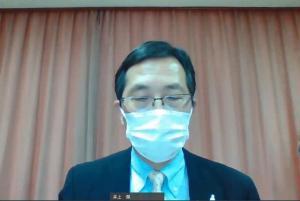 講演を行う眼鏡とスーツ姿の男性の写真