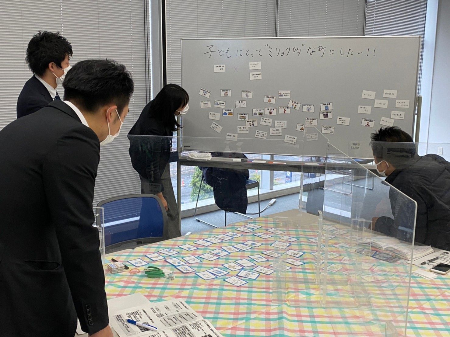 グループワークにおいて、かすかべSDGsパートナーズ会員の強みを記載したリソースカードをホワイトボードに貼り付け、リソースカードの内容を確認している様子