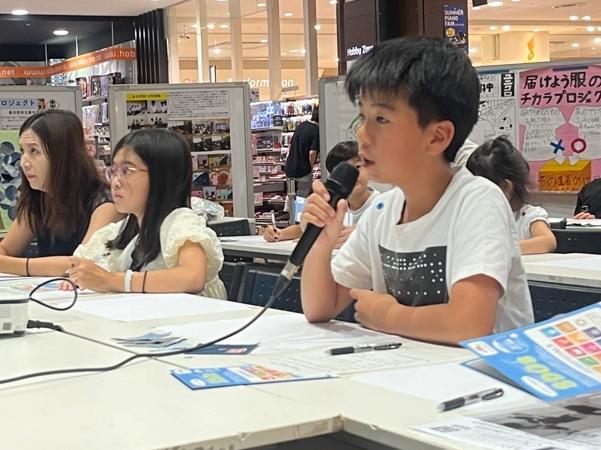 男の子がマイクをを持ち、意見を発表する様子