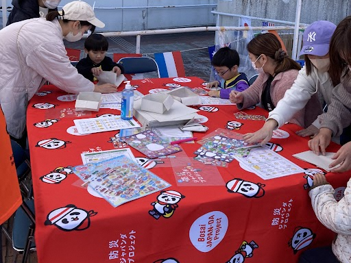 大きなテーブルで紙を使って食器を作る様子