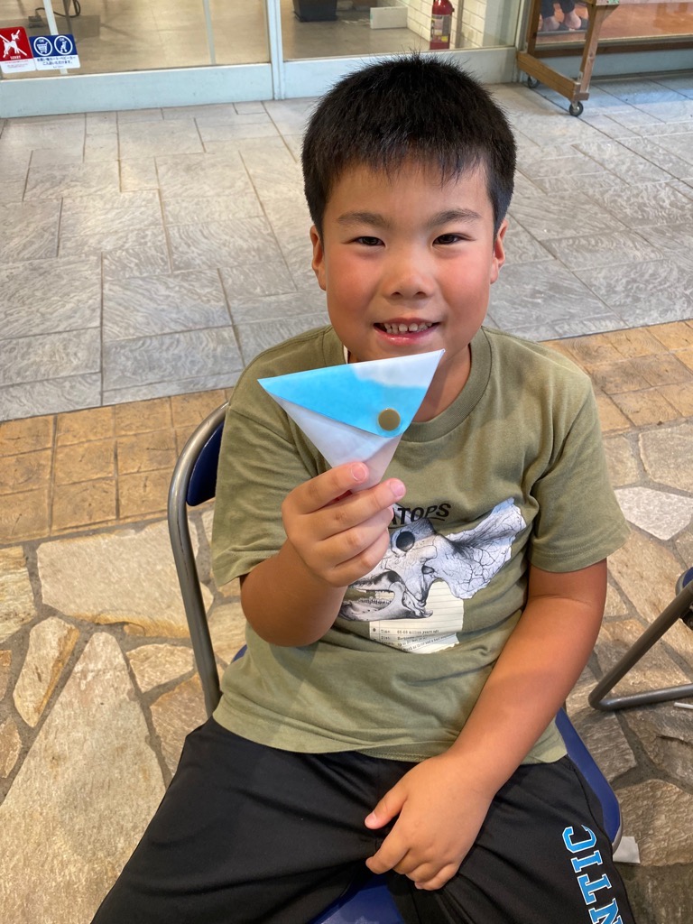 完成した小物ケースを手に持ち、笑顔の男子児童