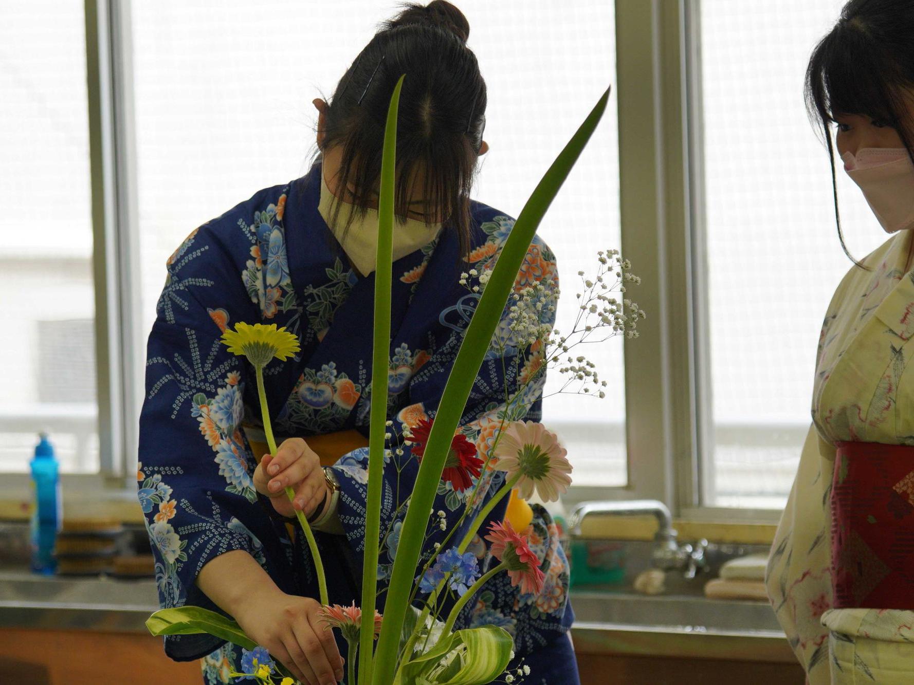 高校生2名が植木に花を植える様子