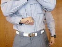 握りこぶしをみぞおち付近に押し当てている写真