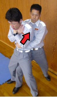 窒息している演技をしている人を両手でみぞおち付近を抱え自分側に引き上げている様子の写真