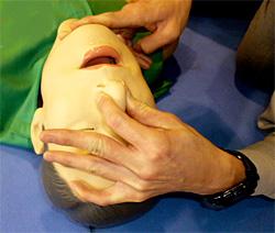 救助訓練マネキンの鼻をつまんでいる様子の写真