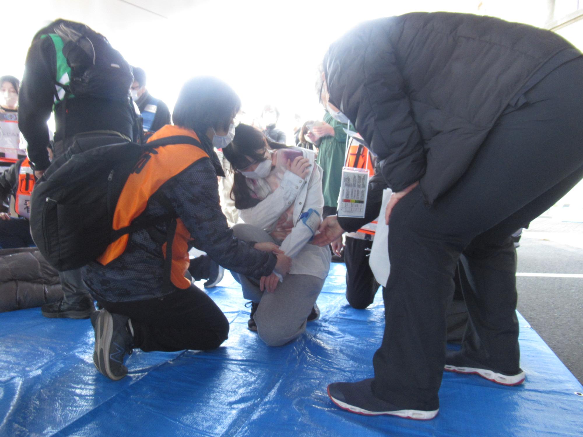 負傷者役の学生を救護する医療従事者の様子