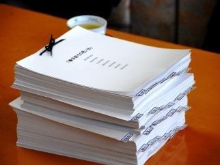 春日部の思い出について書かれた書類の束が、机の上に積まれている写真