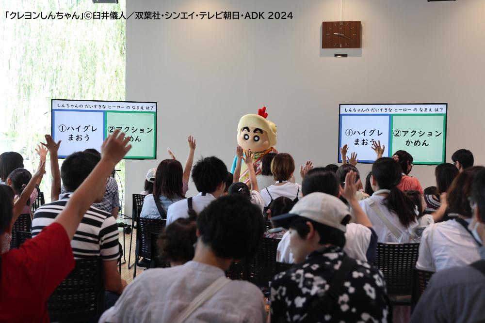 クイズに回答する参加者と恐竜姿の野原しんのすけくん