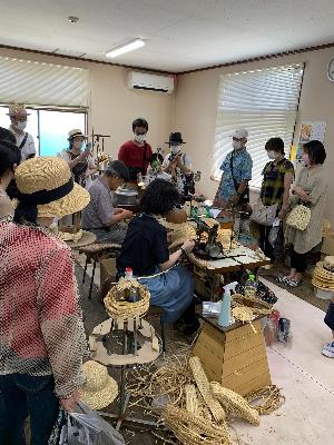 職人さんが麦わら帽子をミシンで縫っています