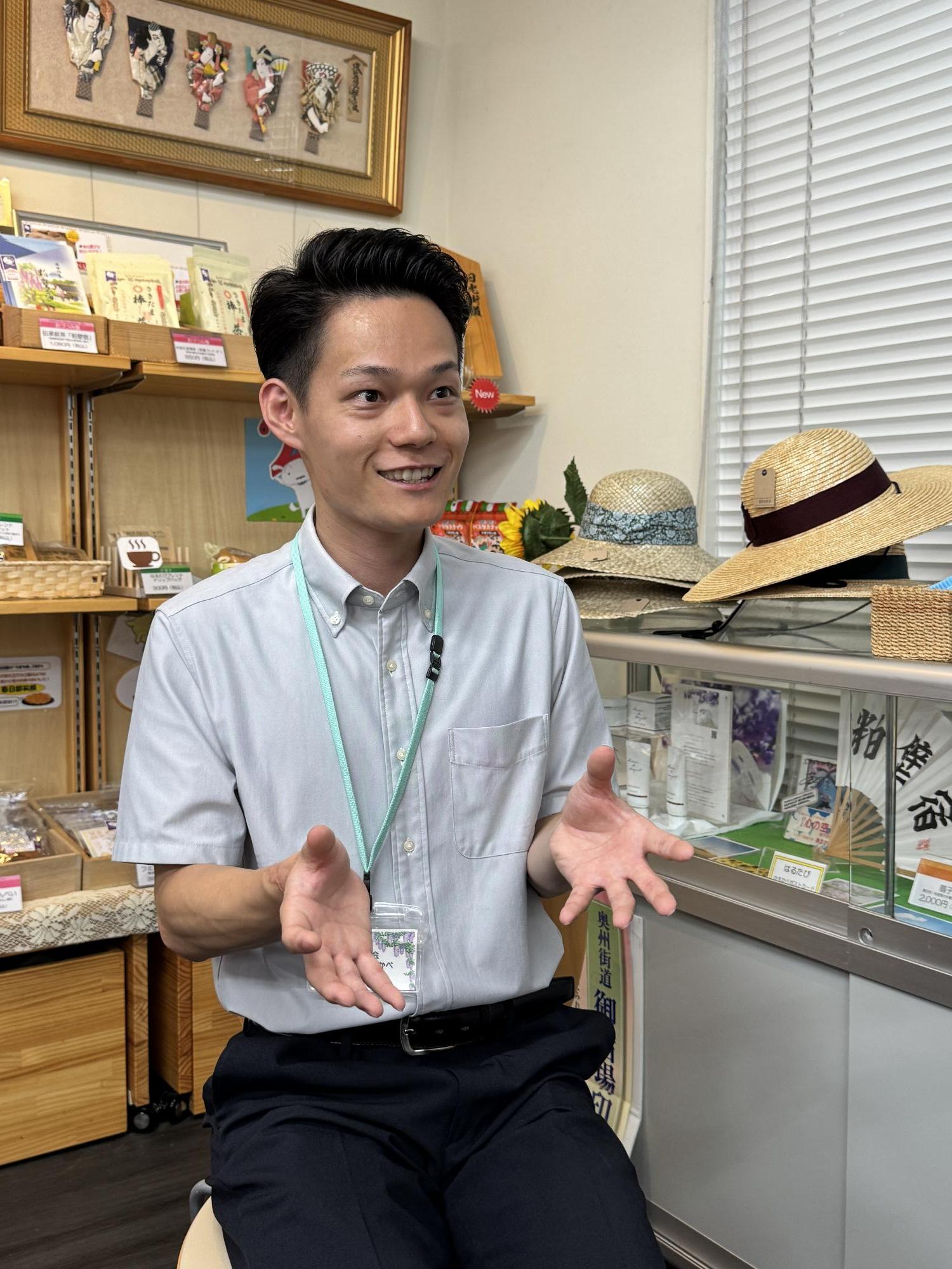 ぷらっとかすかべの施設内で、身振り手振りを交え、お話しをする日留田さんの様子。