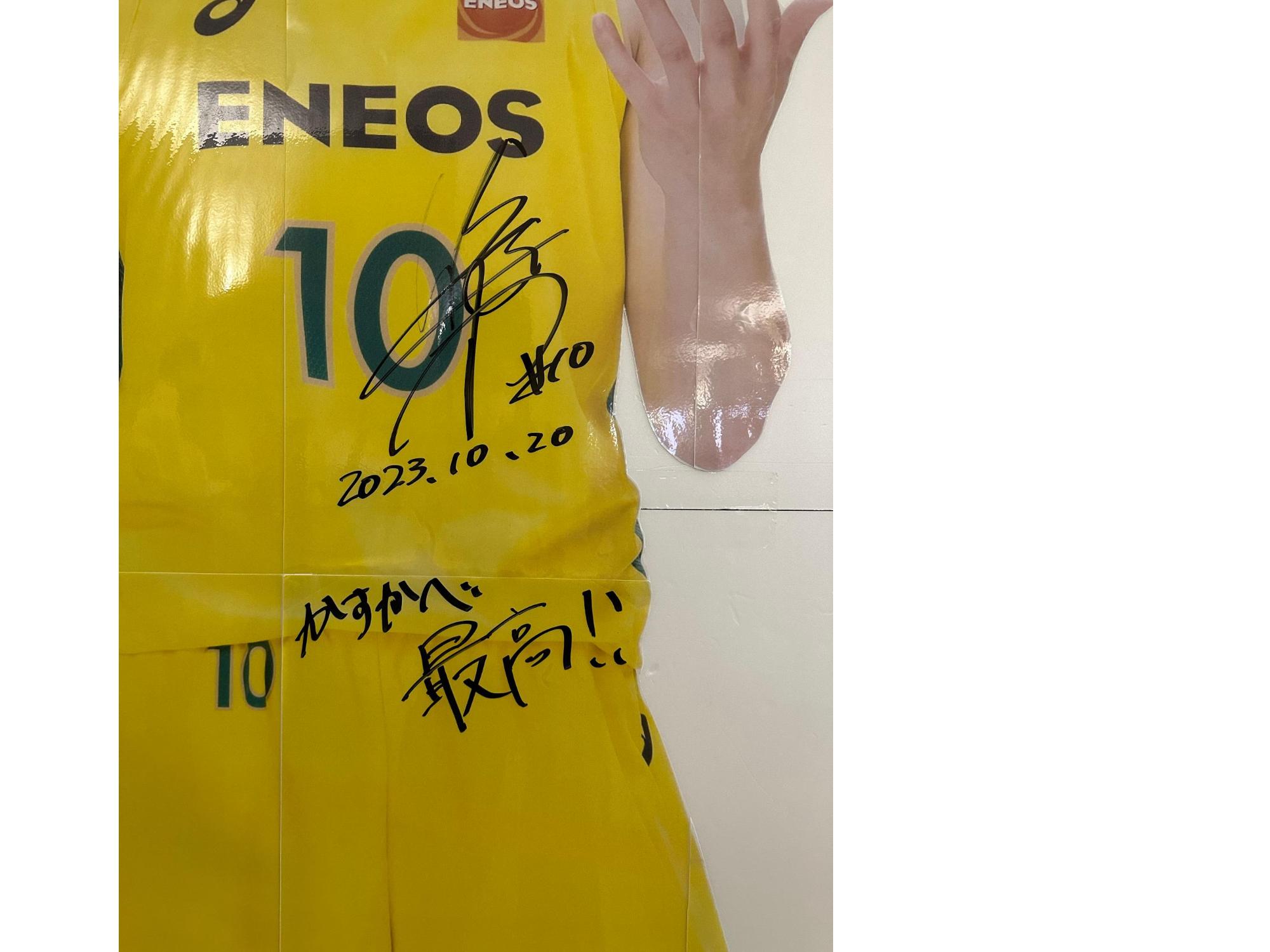 等身大パネルに書かれた渡嘉敷大使のサイン