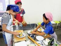 真剣な表情でデザートの飾りつけをしている親子の写真