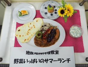 ナス、ゴーヤー、カボチャなどが載った夏野菜カレーとナン、副菜が並ぶサマーランチの写真