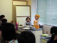 エプロンを来た子供が立って感想を話している写真