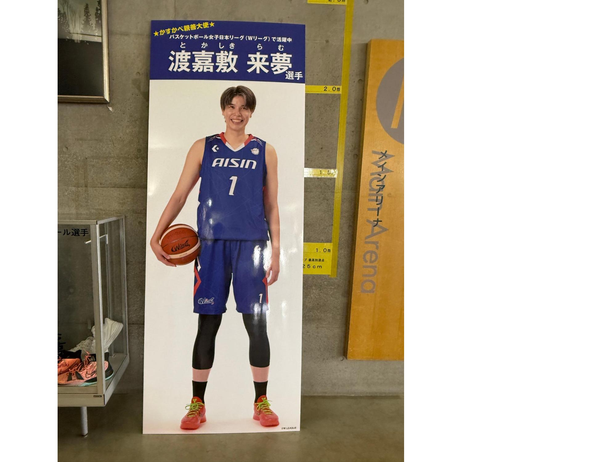 バスケットボールを持って、笑顔をみせる渡嘉敷大使の等身大パネル