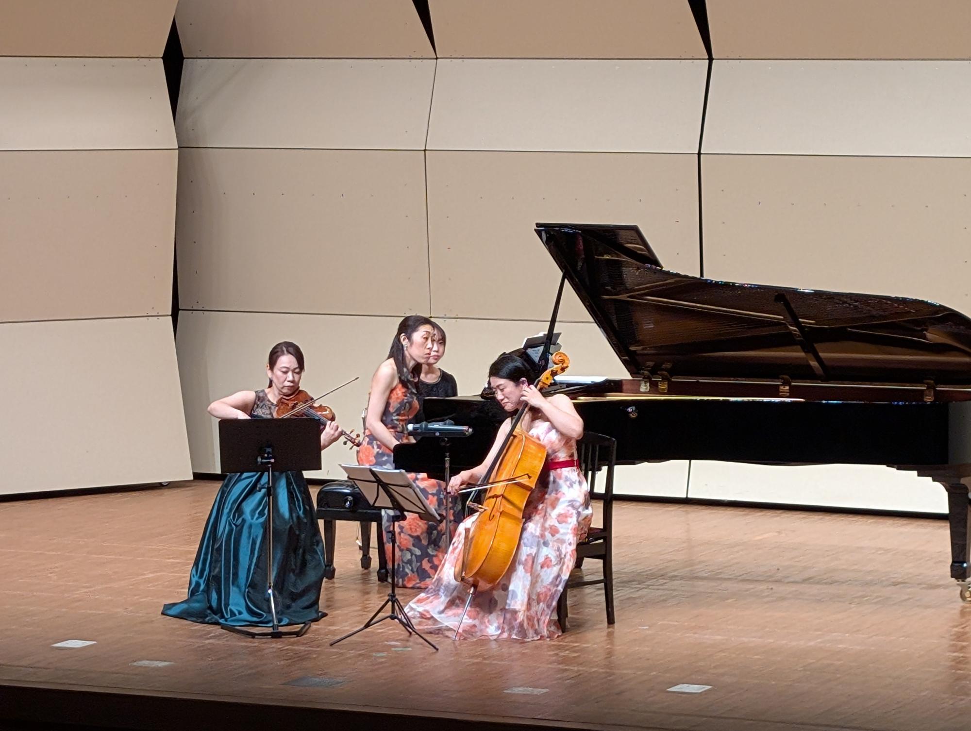 ステージでチェロとヴァイオリンとピアノを演奏する様子