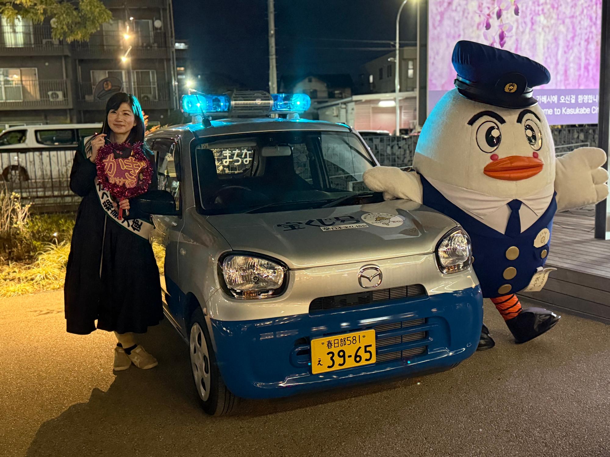 青パトと一緒にポーズをとる井田大使