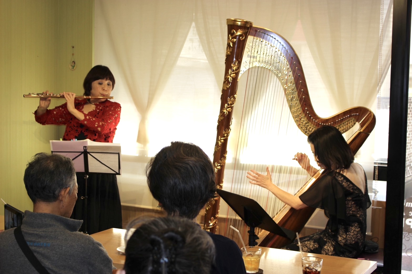 カフェでフルートとハープを演奏する様子