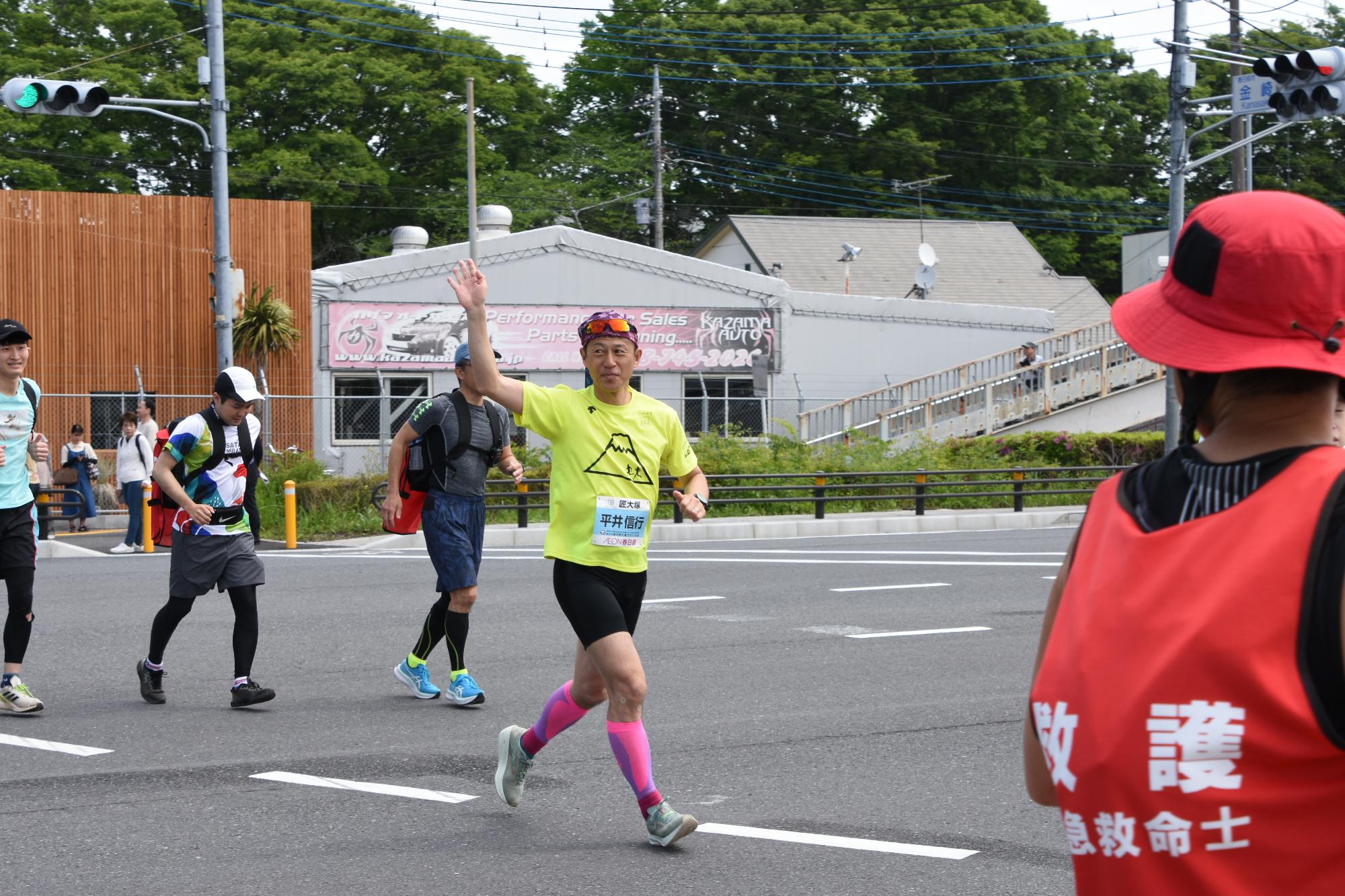 沿道の応援に手を振る平井大使