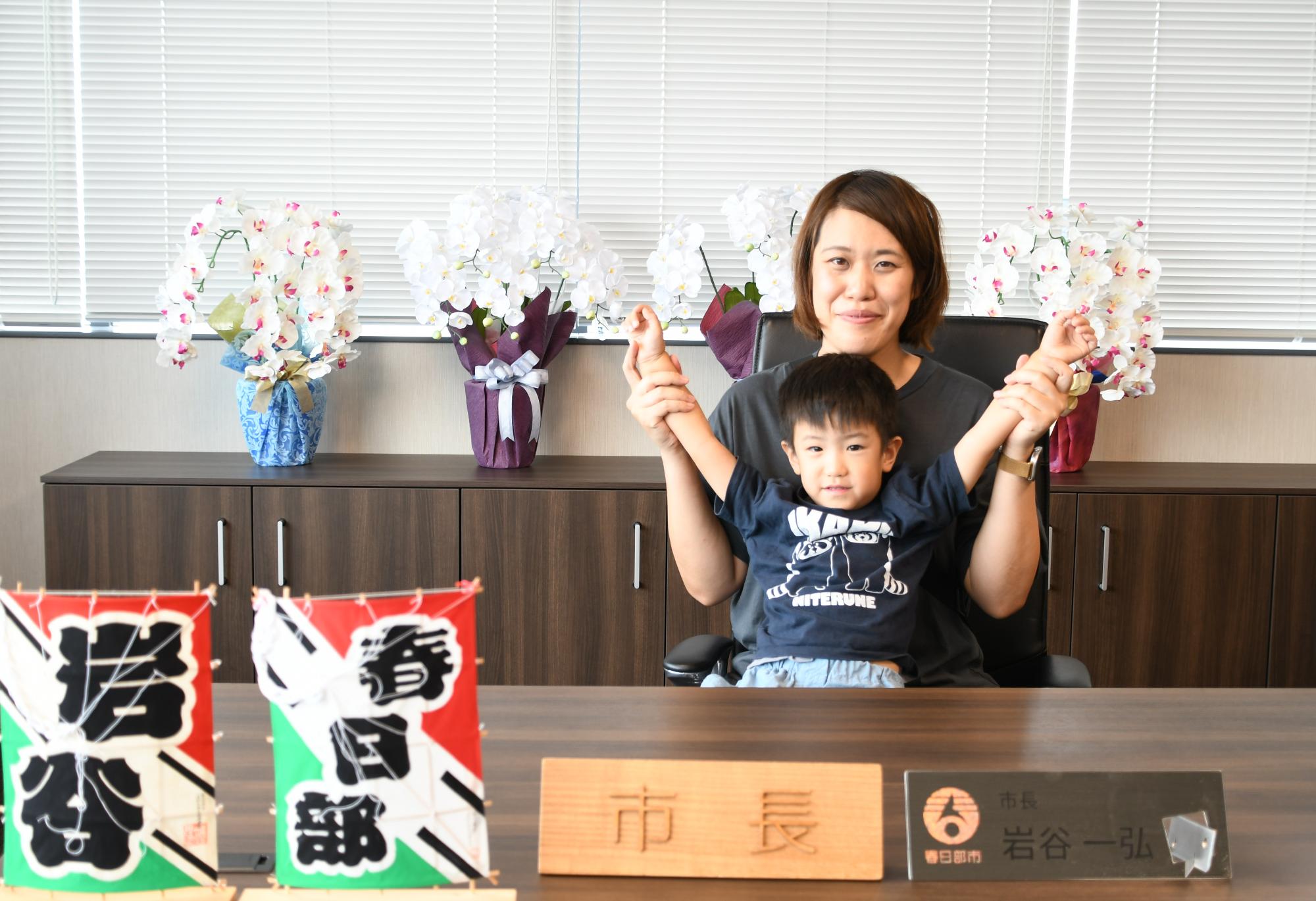 市長席で記念撮影を行う親子の写真