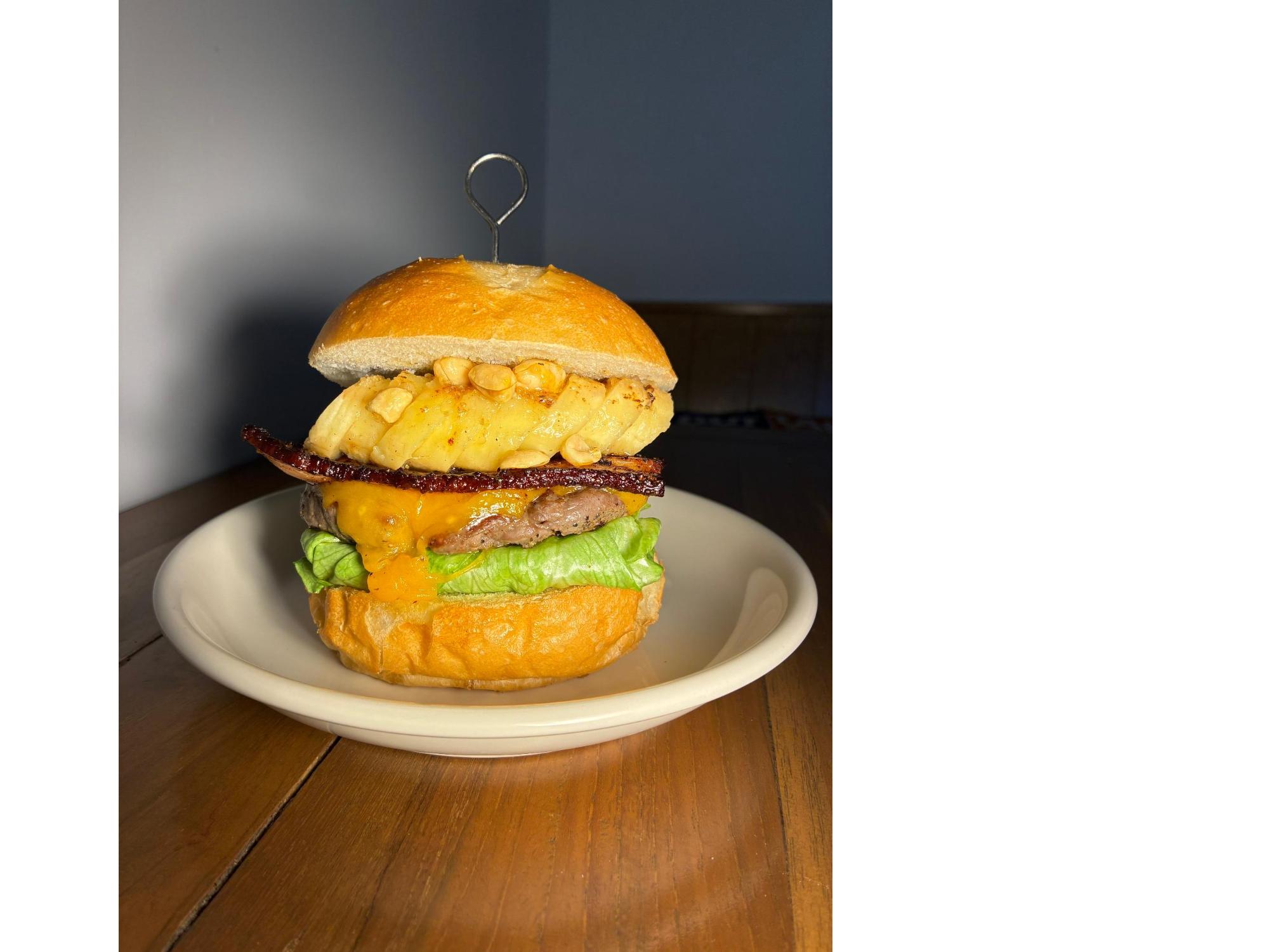 バンズに素揚げしたバナナやパティ、チーズがはさまれた「エルビスチーズバーガー」の写真