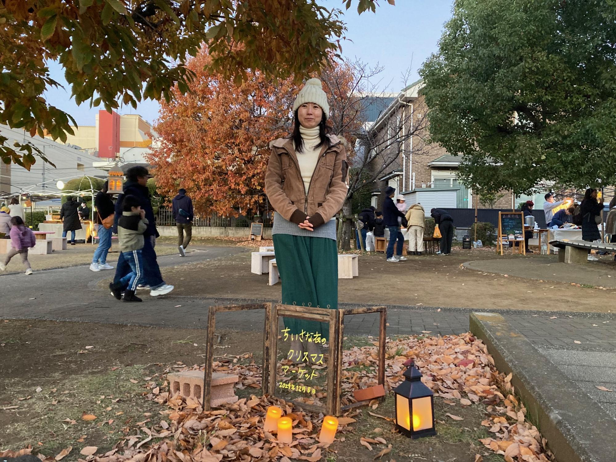 イベントの看板の前で写るナオナさん